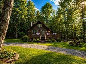 Eine Hütte mit Veranda, umgeben von Bäumen.