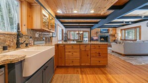 Una cocina amplia con armarios de madera, una isla grande y un salpicadero de piedra.