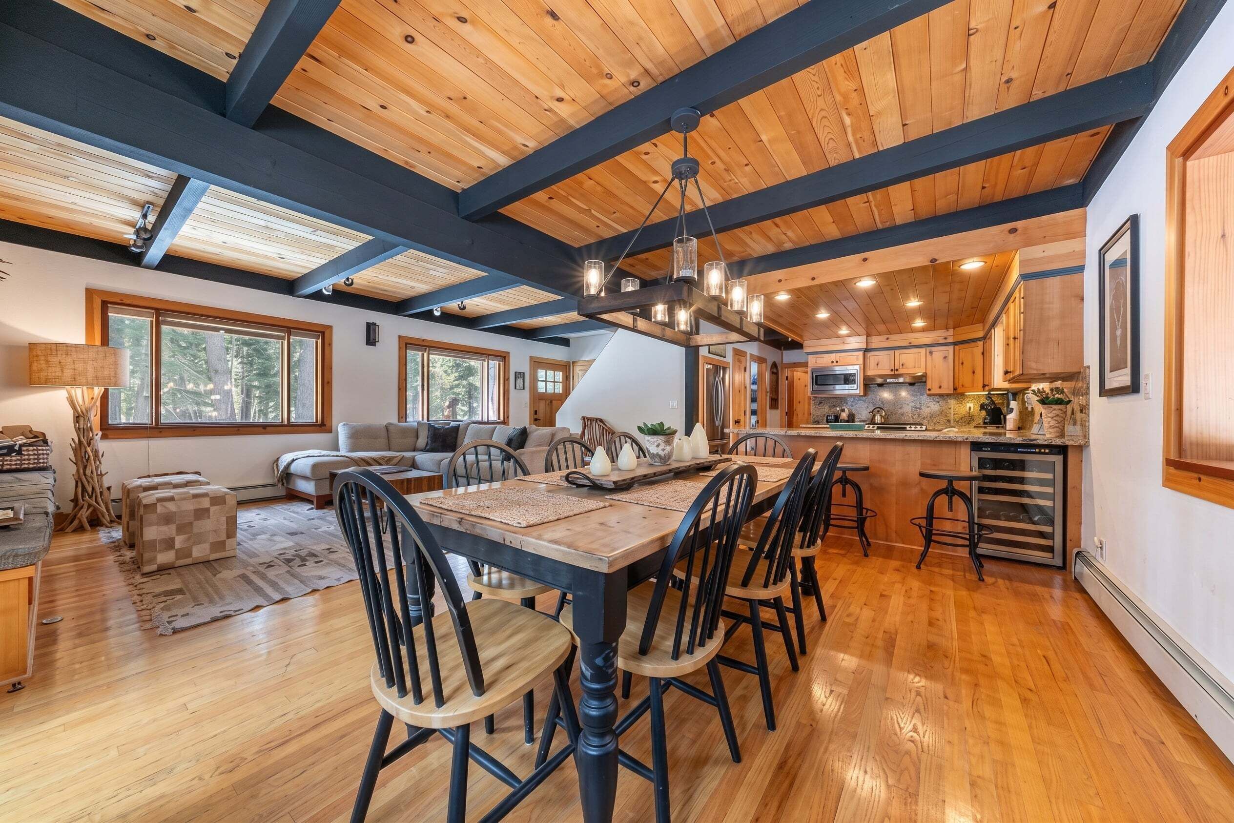 A spacious kitchen with wooden cabinets, a central island, and a dining area with a long table and chairs.