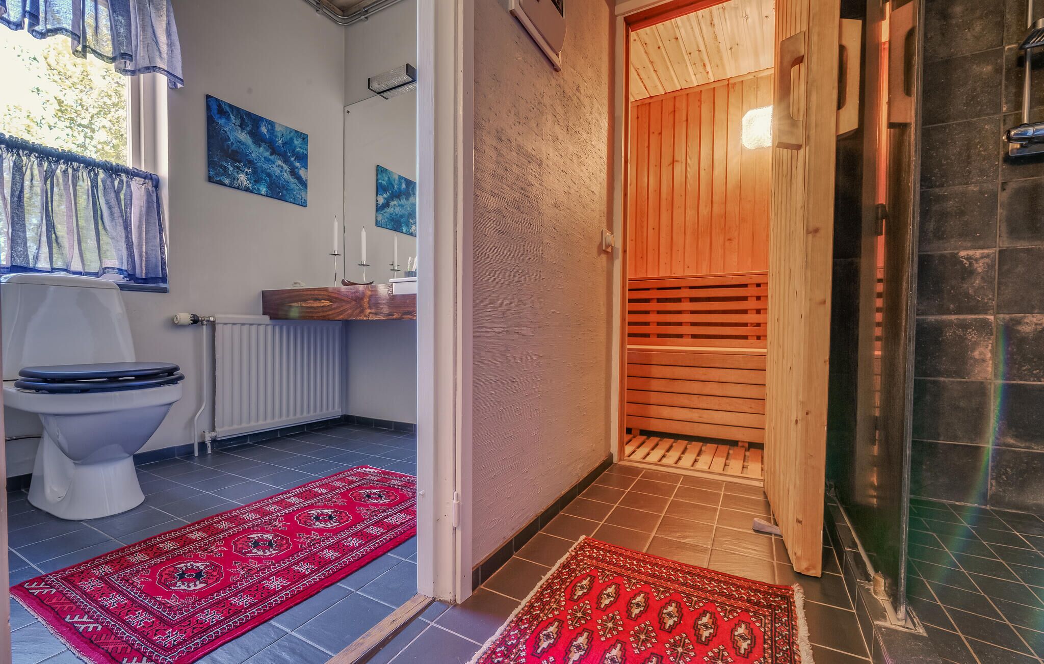 A bathroom with a toilet, sink, and shower area.