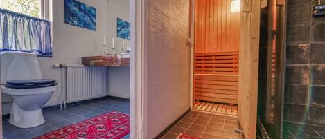 A bathroom with a toilet, sink, and shower area.