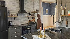 Una cocina moderna con armarios oscuros, una campana extractora negra y una encimera de mármol.