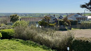 A residential area with houses, a clear sky, and a distant view of the countryside.