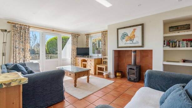 A living room with a sofa, a coffee table, a TV, a fireplace, and a bookshelf.