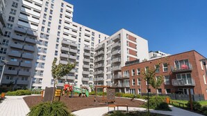 A residential building with multiple balconies and a playground area with play equipment. - Business Deluxe Studio 38 (Katowice)