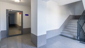 A hallway with a door leading to a stairwell. - Business Deluxe Studio 38 (Katowice)