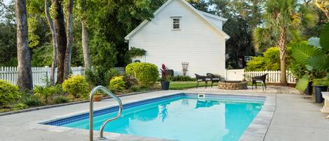 A rectangular swimming pool with a tiled edge, surrounded by a concrete deck.