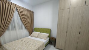 A bedroom with a bed, curtains, a wardrobe, and a nightstand.