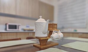 Una cucina con un forno a microonde, un bollitore e una tazza su un ripiano di legno.