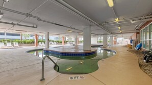 An indoor swimming pool area with a 3 FT depth marker, lounge chairs, and a poolside area with a view of the outside. - Stay Elevated – North Myrtle Beach 3BR Penthouse at Malibu Pointe Resort (North Myrtle Beach)