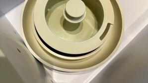Ein runder Gegenstand mit einer zentralen Drehknopf, möglicherweise ein Bauteil einer Maschine oder Anlage.