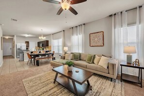 Ein modernes Wohnzimmer mit Sofa, Couchtisch und Essbereich.