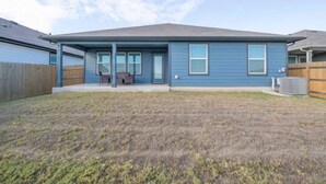 A residential house with a front porch, a covered patio, and a fenced backyard. - 4BR Corporate Stay in Hutto (Hutto)