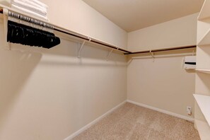 A closet with hanging storage and a carpeted floor.