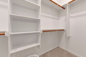A corner closet with white walls, a wooden beam, and a white door. - Luxurious 4-Bedroom House (Temple)