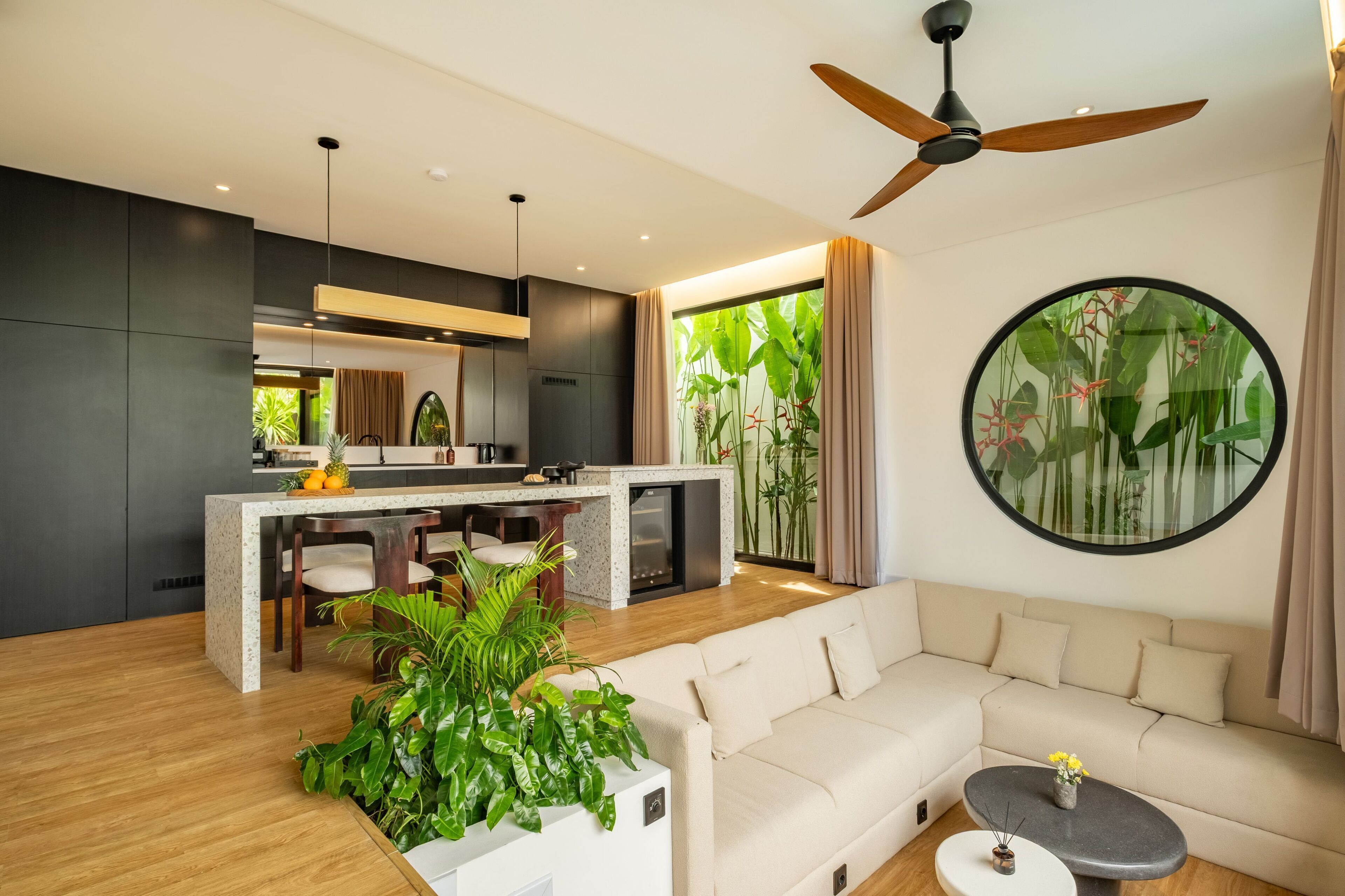 Una sala de estar moderna con sofá, una mesa de centro y una zona de cocina con mesa de comedor.