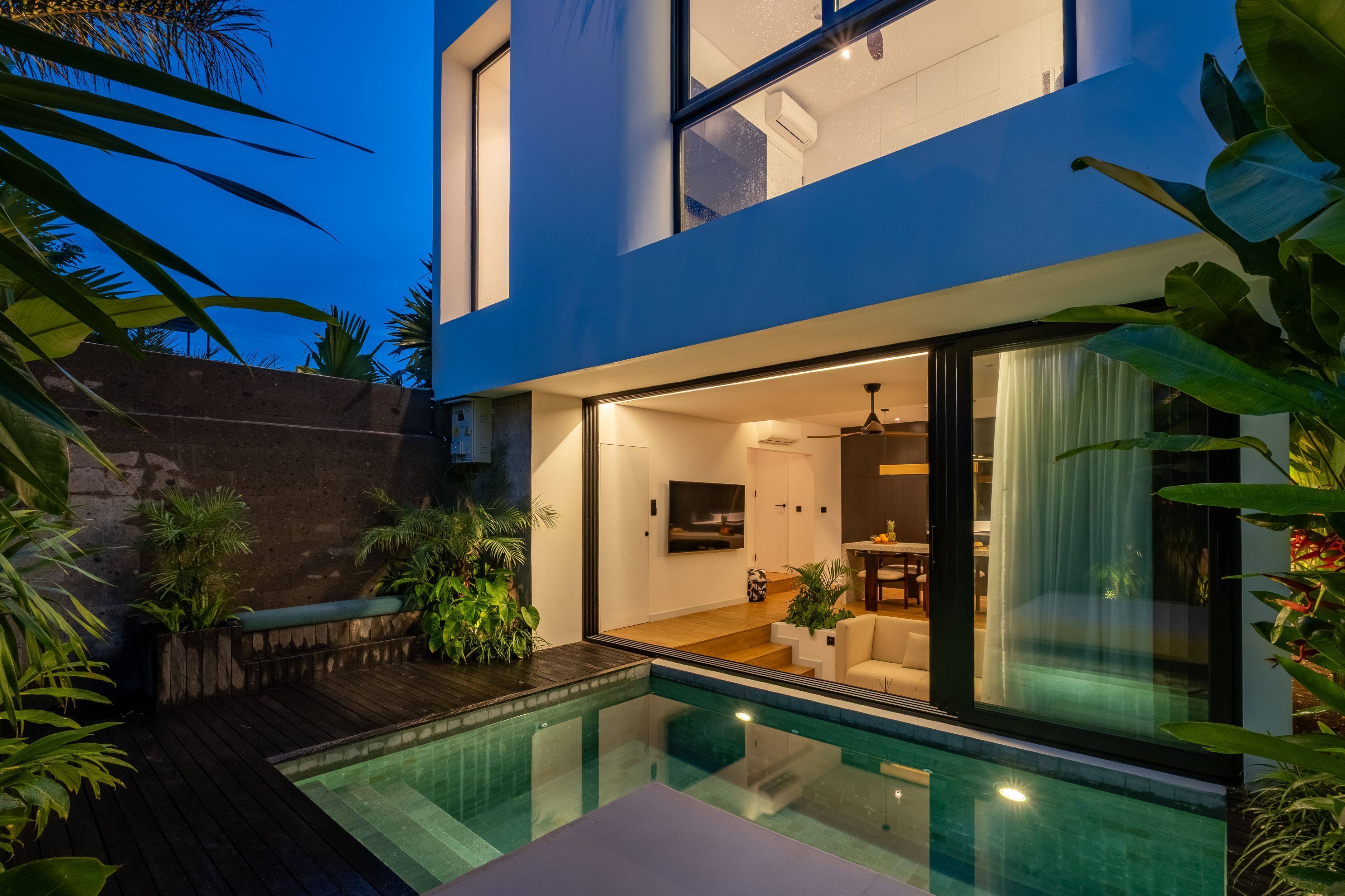 Una casa moderna con piscina, un patio y un interior bien iluminado.