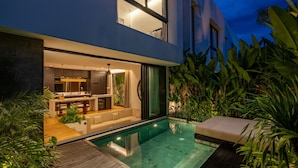 A modern house with a swimming pool, a dining area, and a kitchen. - Club Suma Villa Bingin (Pecatu)