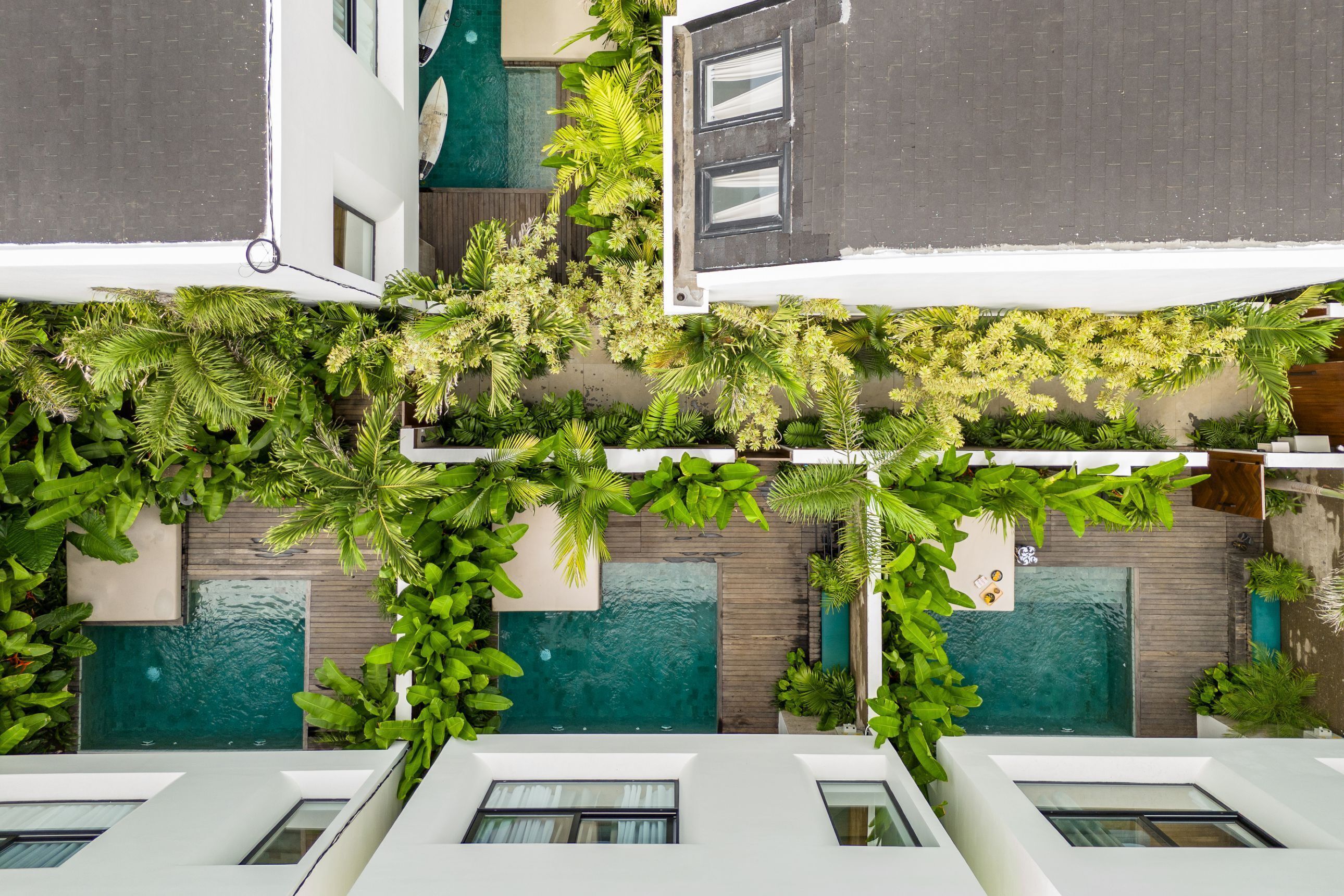 A modern building with a rooftop garden, a swimming pool, and a view of the surrounding area.