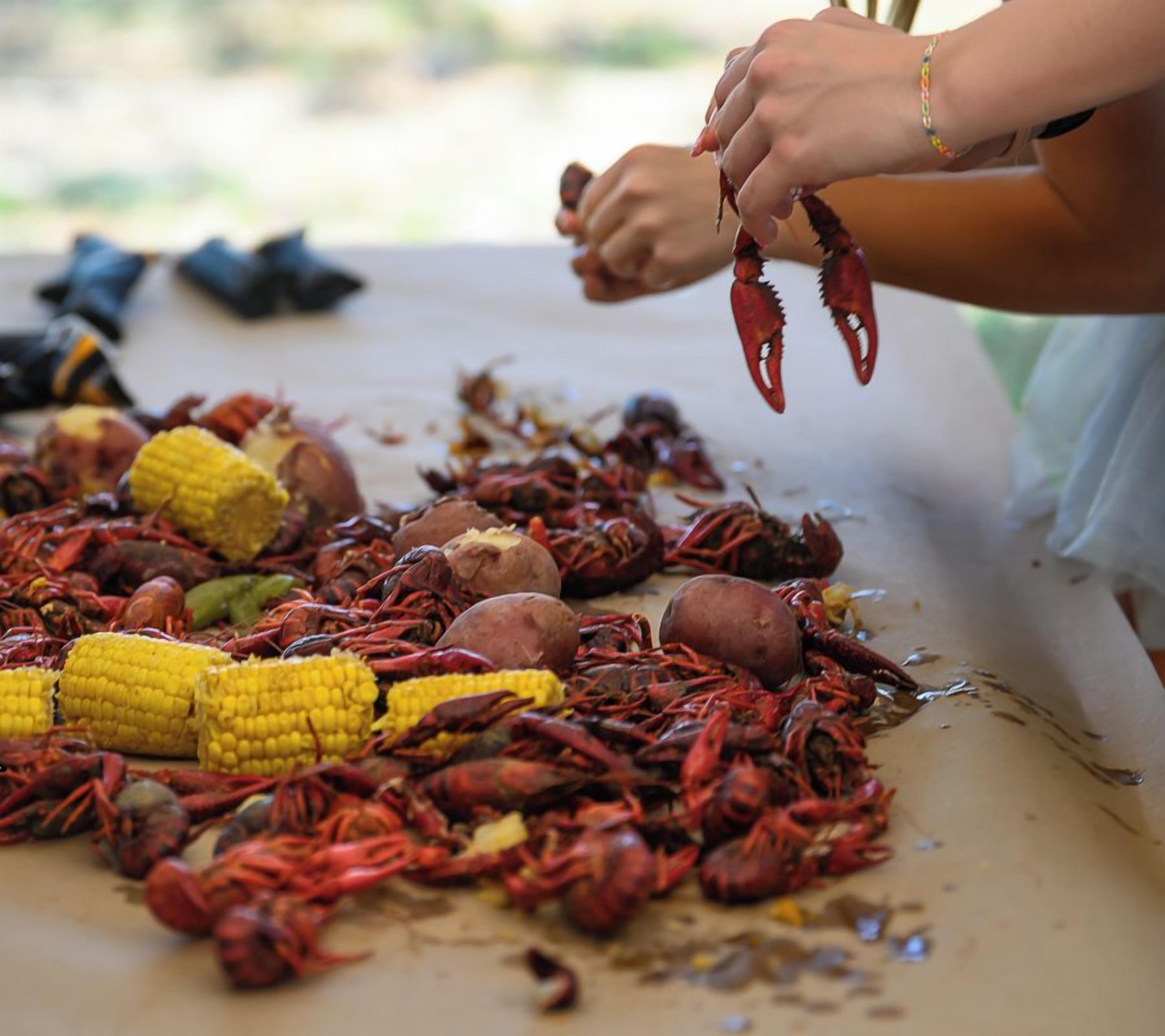 A table with crawfish, corn, and potatoes, likely for cooking.