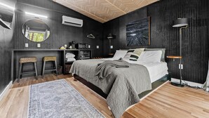Une chambre moderne avec un lit, des lampes de chevet, un bureau et un luminaire suspendu.