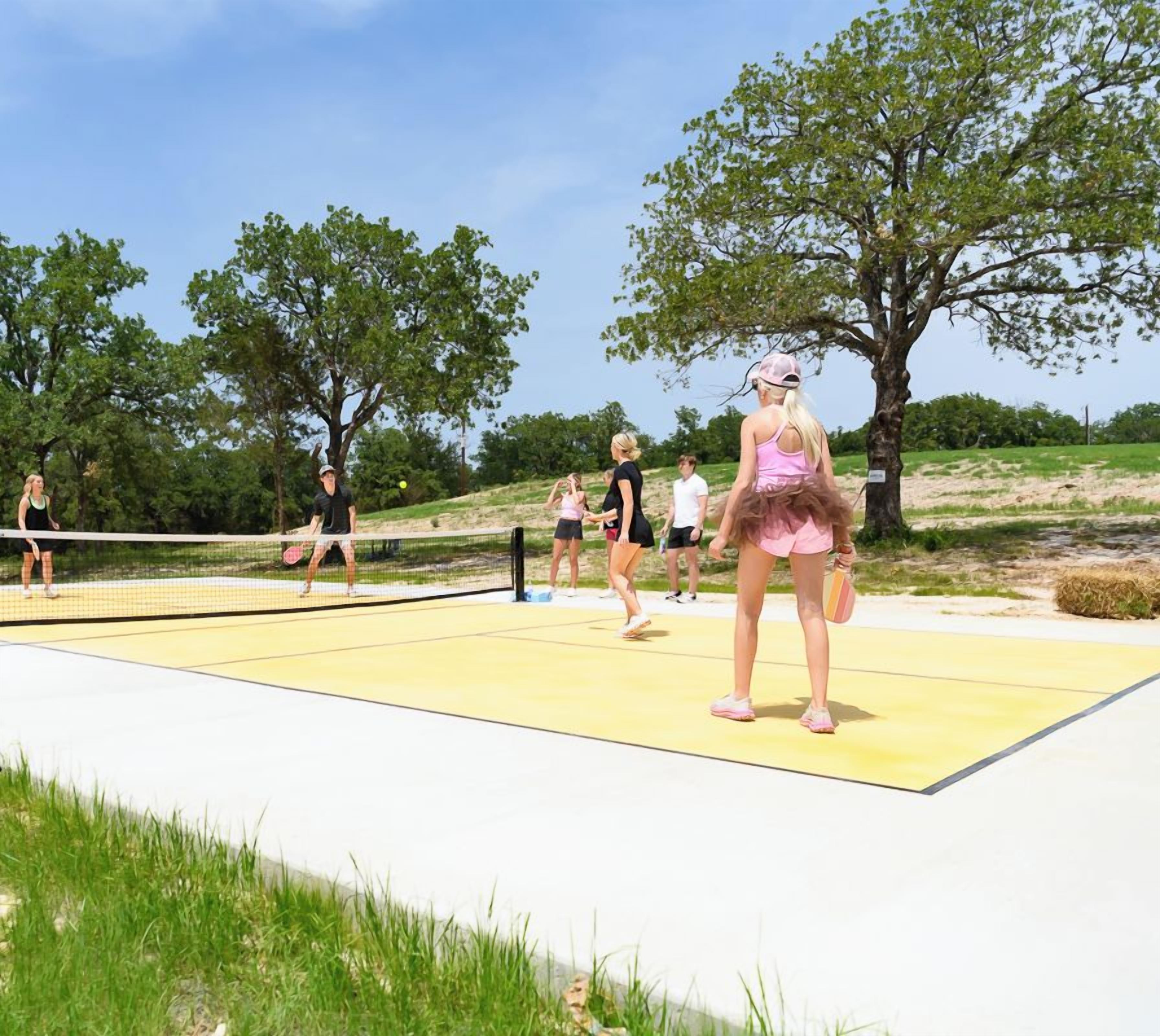 Una cancha de voleibol con jugadores, árboles y el logotipo de 4Forty4 Ranch.