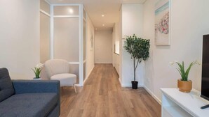 Een moderne woonkamer met een bank, een televisie en een plant.