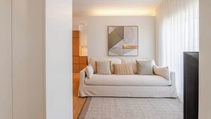 A modern living room with a sofa, a geometric wall art piece, and a television. - Stylish & Spacious Apartment by HostWise (Porto)