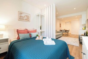 Une chambre d’hôtel moderne, dotée d’un grand lit, d’un bureau et d’un coin repas.