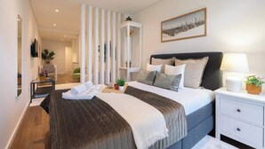 Un dormitorio moderno con una cama grande, mesitas de noche y una repisa en la pared.