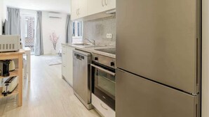 Une cuisine moderne dotée d’appareils électroménagers en acier inoxydable, d’une table en bois et offrant une vue sur l’espace de vie.
