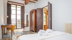 A bedroom with a bed, a desk with a chair, a wardrobe, and a window with open shutters. - CASA MALLORQUINA CON ENCANTO - Rustic village house with private pool and free WiFi (Mancor de la Vall)