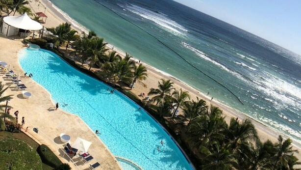 Un complexe hôtelier doté d’une grande piscine, d’une plage et offrant une vue sur l’océan.