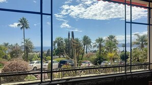 A balcony with a view of parked cars and palm trees, overlooking a coastal area. - Studio l`Atelier – Parking & Beaches 15 min Walk (Cannes)