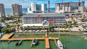 Un hotel con varias unidades, un puerto deportivo con barcos y vista al océano.