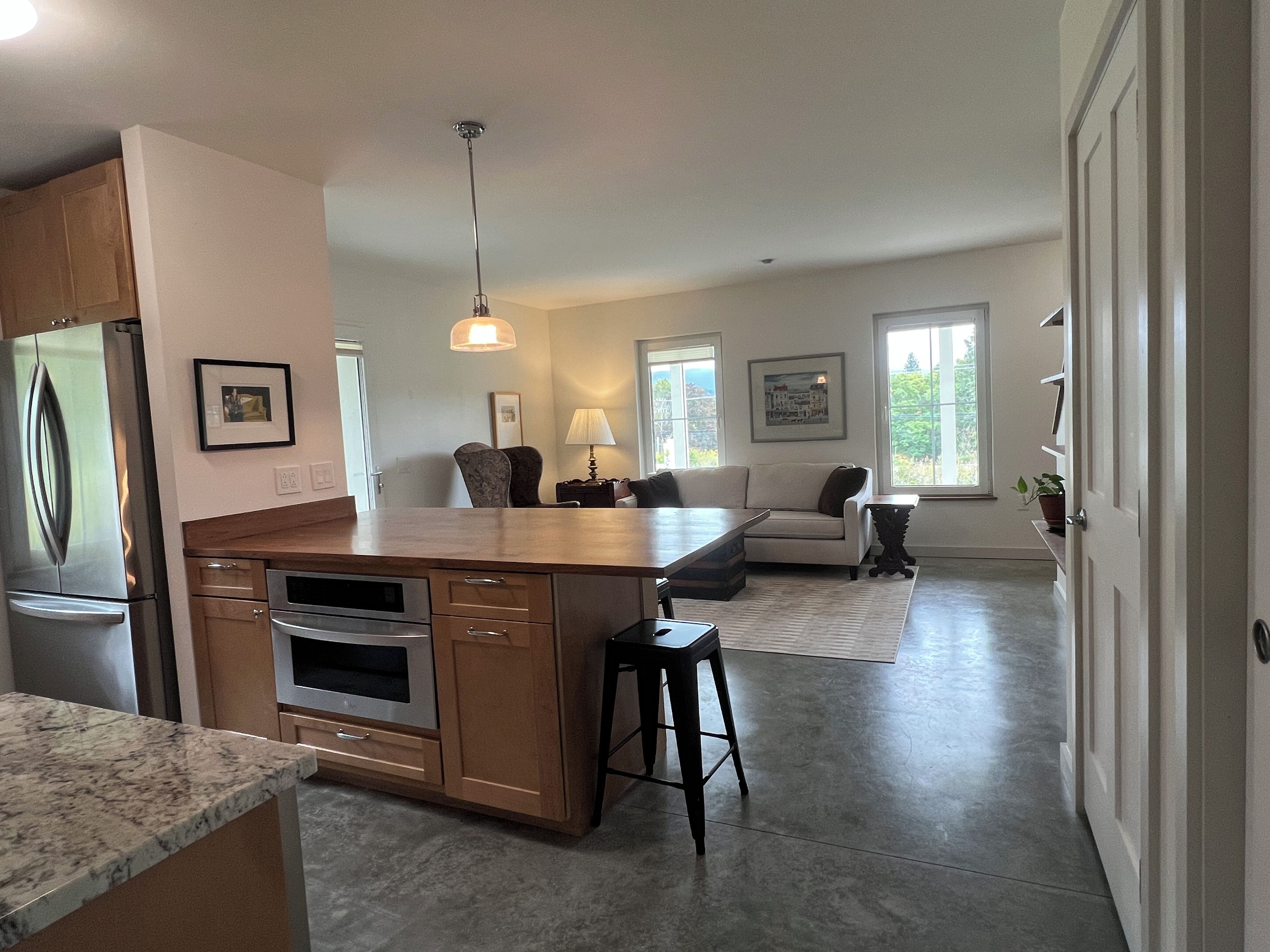 A modern kitchen with a central island, built-in appliances, and a dining area with a sofa and chairs.