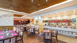 A restaurant with multiple dining tables and chairs, a buffet area with food displays, and a modern ceiling design. - Bo'ao Heyue Seaview Hotel (Qionghai)