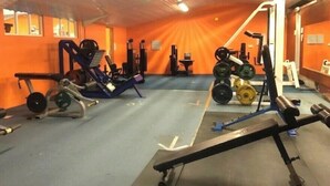 A gym with various exercise equipment, including a bench press, squat rack, and weight benches. - Comfort & Peace 5Berth Family Friendly Park (St Austell)