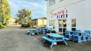 Snowy's Diner with outdoor seating and a gravel driveway. - Comfort & Peace 5Berth Family Friendly Park (St Austell)