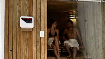 Uma sauna com exterior de madeira e painel de controle digital.