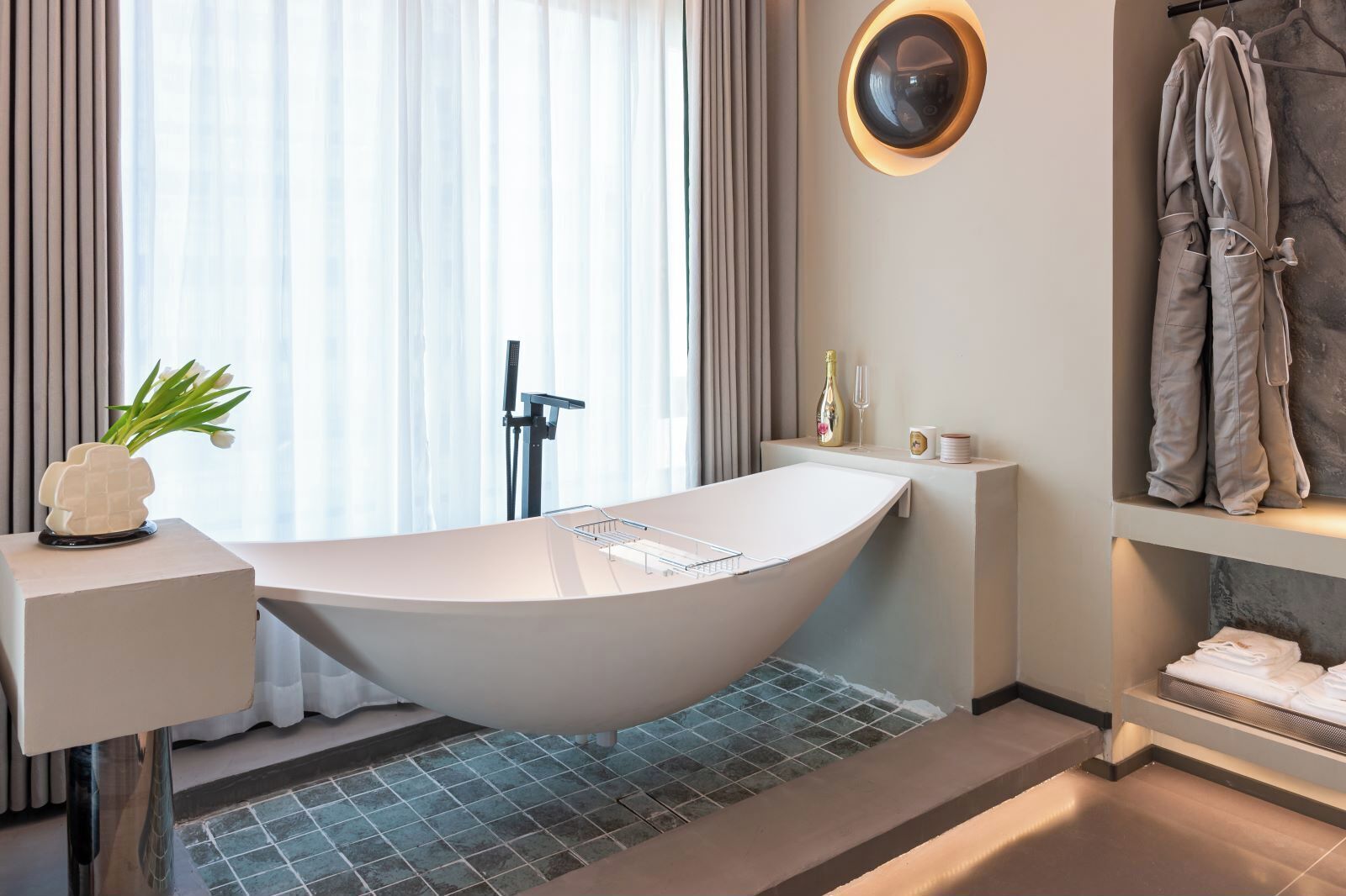A modern bathroom with a freestanding bathtub, a vanity with a mirror, and a towel rack.