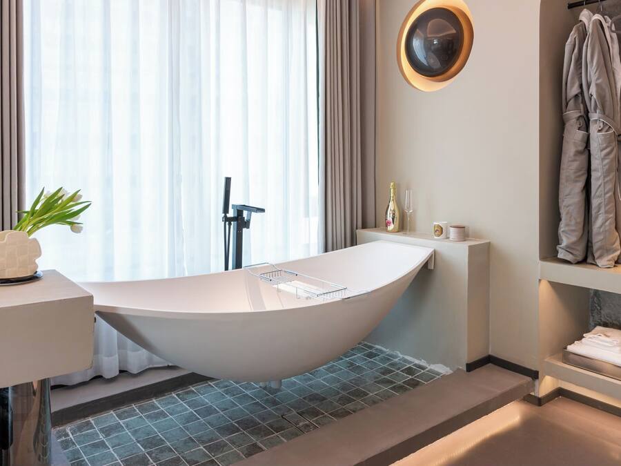A modern bathroom with a freestanding bathtub, a vanity with a mirror, and a towel rack.
