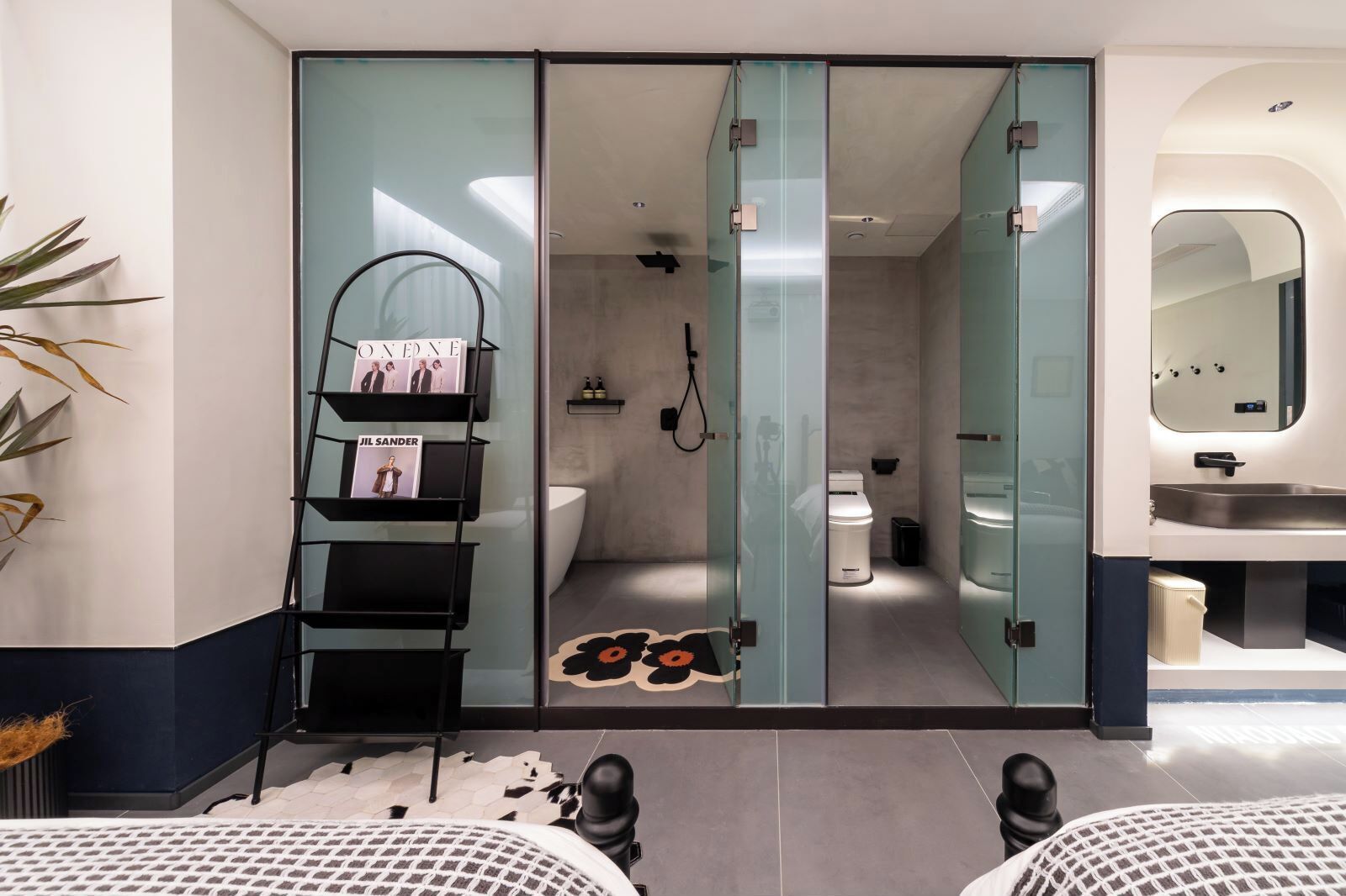 Et moderne badeværelse med glasafskærmning, toilet, bidet og håndvask.