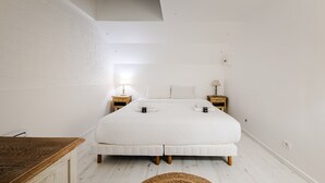 Una camera da letto con un letto grande, due comodini, un comodino in legno e un tavolino.