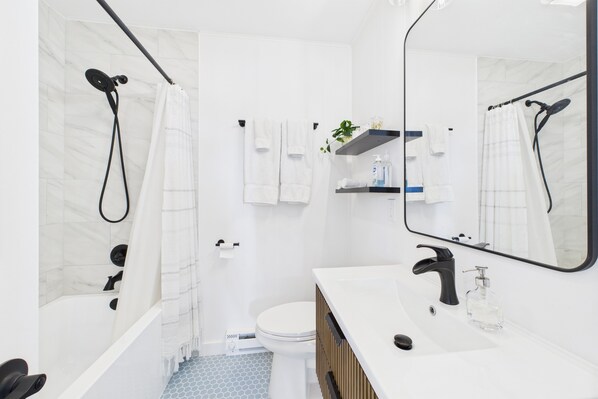 Un baño moderno con bañera, inodoro y lavamanos.