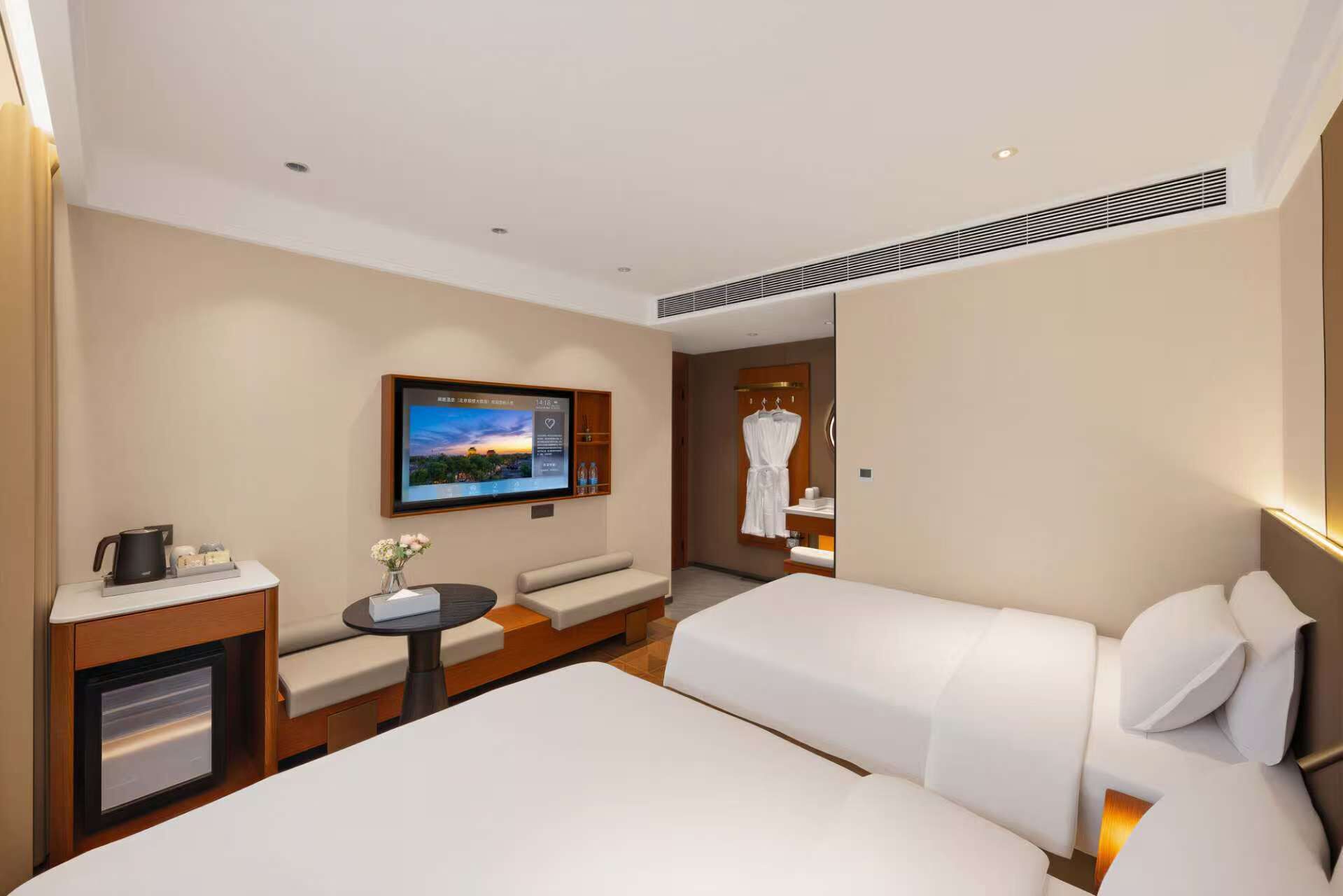 Une chambre d’hôtel comprenant un lit, un coin salon, une télévision et une salle de bain.