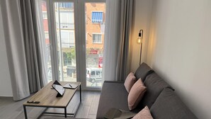 Una sala de estar moderna con un sofá gris, una mesa de centro de madera y un control remoto.