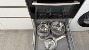 Un horno de acero inoxidable con puerta de cristal, una rejilla interna y un panel de control con ajustes de temperatura y temporizador.