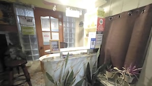 A reception area with a counter, a chair, and potted plants. - D and A Transient Inn Taguig (Taguig)