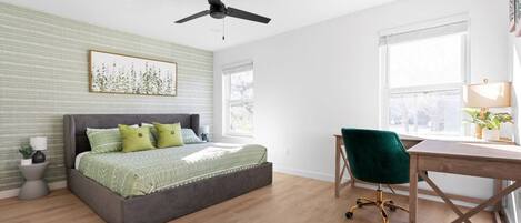 A bedroom with a bed, a desk, and a chair.